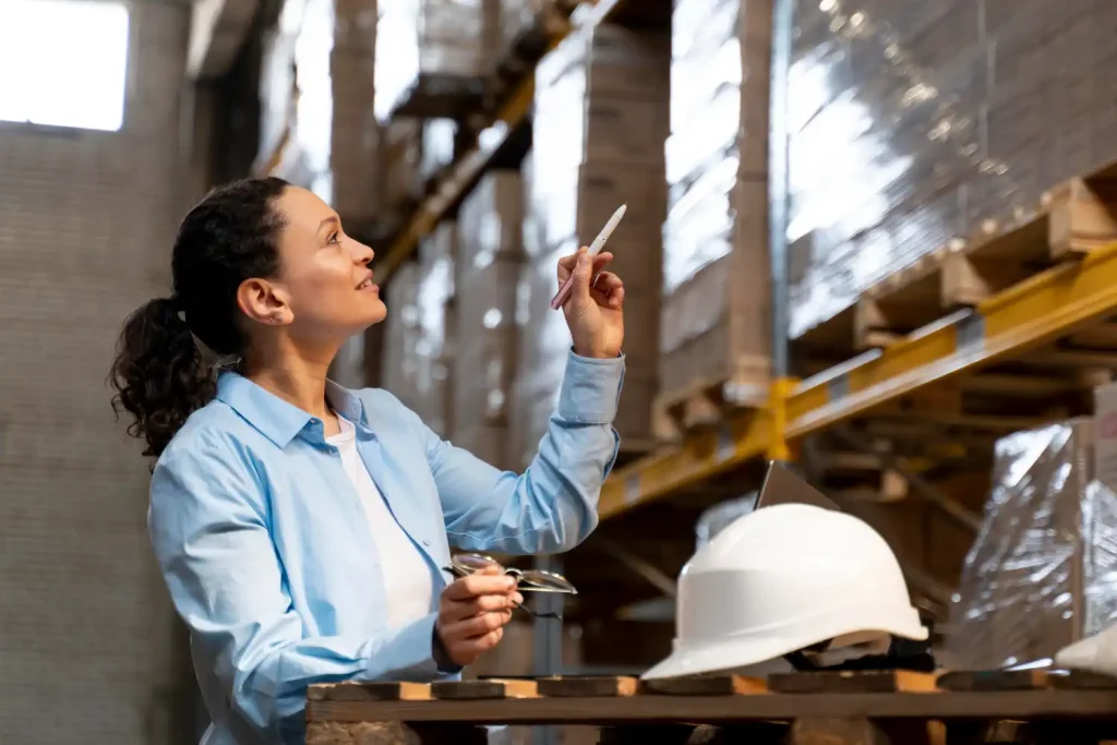 Profissional na indústria 4.0 em Jaraguá do Sul analisando dados tecnológicos em um armazém, representando inovação e automação no setor industrial.