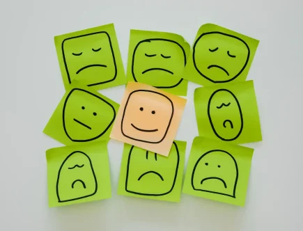 Imagem representativa da análise de sentimentos, com adesivos e expressões faciais que ilustram emoções variadas, destacando a importância do conceito e suas aplicações.