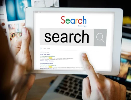 Pessoa utilizando tablet para pesquisar no Google sobre como organizar conteúdo com heading tags para agradar algoritmos do Google.