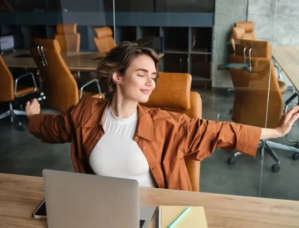 Mulher praticando mindfulness no ambiente de trabalho, com postura de atenção plena, promovendo foco, produtividade e bem-estar enquanto trabalha em um escritório moderno.