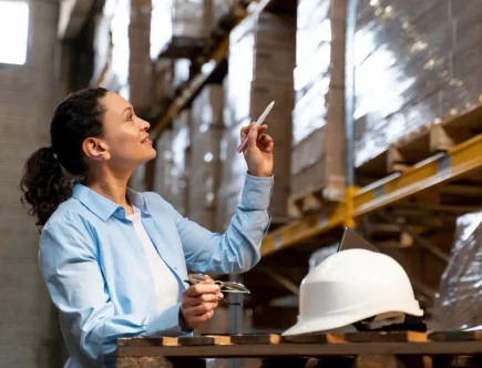 Profissional na indústria 4.0 em Jaraguá do Sul analisando dados tecnológicos em um armazém, representando inovação e automação no setor industrial.