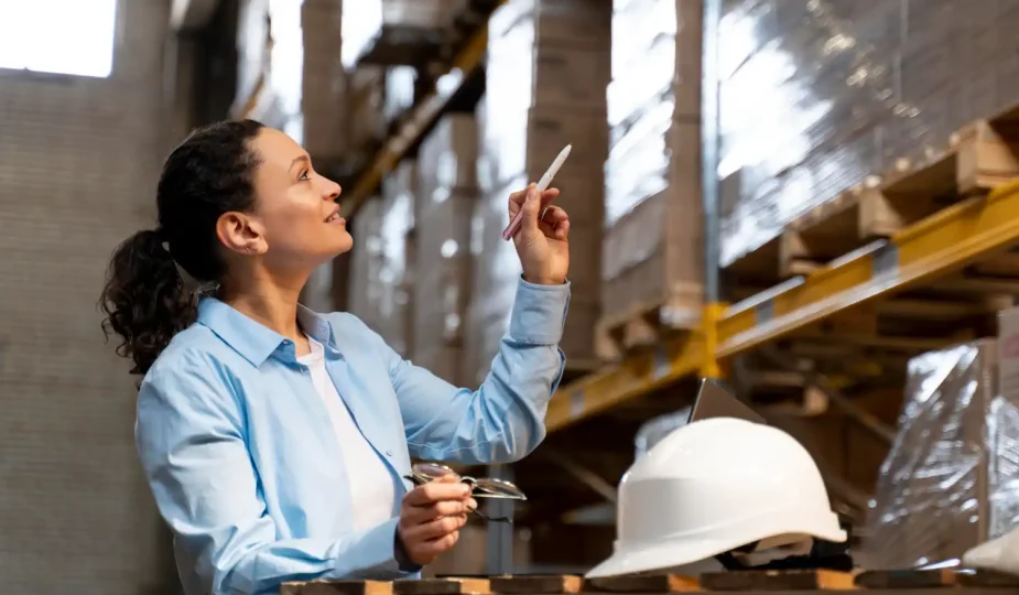 Profissional na indústria 4.0 em Jaraguá do Sul analisando dados tecnológicos em um armazém, representando inovação e automação no setor industrial.