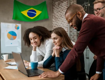 Grupo de pessoas em uma reunião de negócios com a bandeira de Santa Catarina ao fundo, destacando o potencial de empreendedorismo no estado.